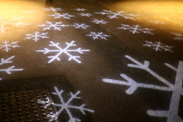 节日的形象，雪花设计，灯光投影照亮柏油路面图片下载