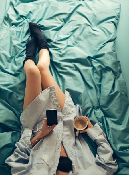 女孩在床上用手机图片下载
