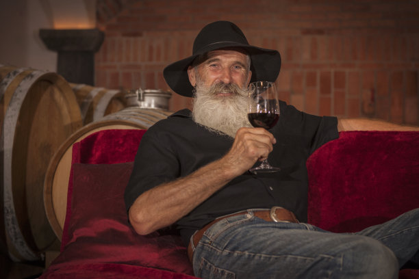 白胡子老人在欧洲酒窖品尝葡萄酒图片下载