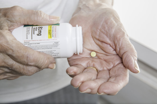 老年妇女关节炎手与阿斯匹林在手特写图片下载