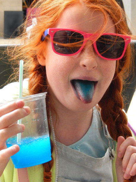 女孩喝冰沙饮料用吸管，冰冻的冰饮料，蓝色的舌头图片下载