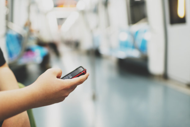 在大城市里，手持智能手机和发短信的青少年图片下载