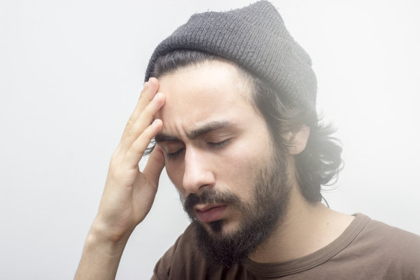 一个年轻人痛苦地抱着他的头图片下载
