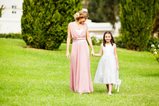 花童牵着伴娘的手在花园里散步图片下载