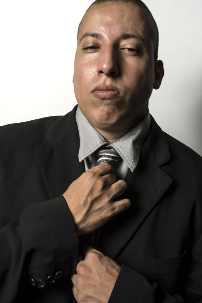 西班牙裔拉丁美洲男性在西装中调整领带图片下载