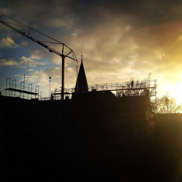 日出时脚手架和起重机图片下载