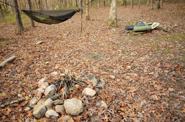 营地篝火，背景是吊床和背包图片下载