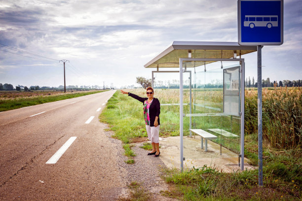 在法国公交车站，一位成熟微笑的西班牙裔女性图片下载