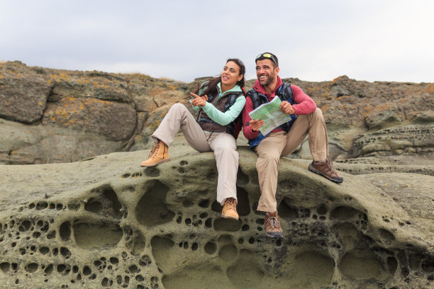 年轻人用地图在岩石上休息图片下载