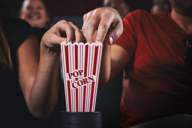 同时伸手去拿爆米花素材图片