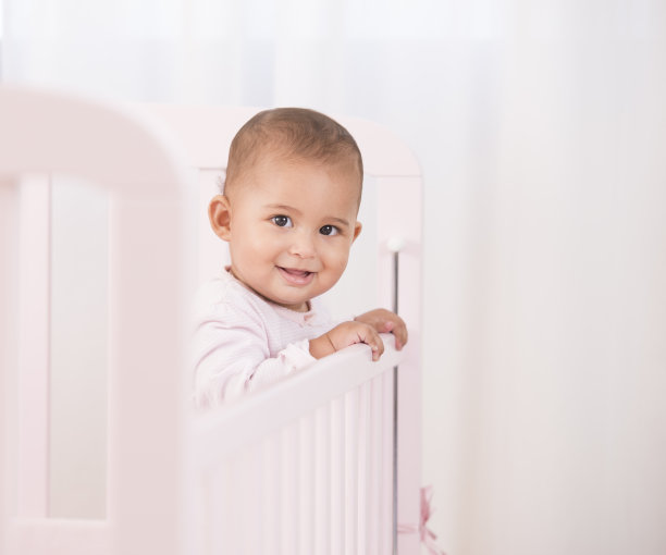 可爱的婴儿在婴儿床的肖像。图片下载