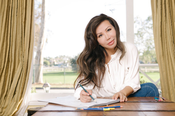 轻松的女人在家里用铅笔涂色图片下载