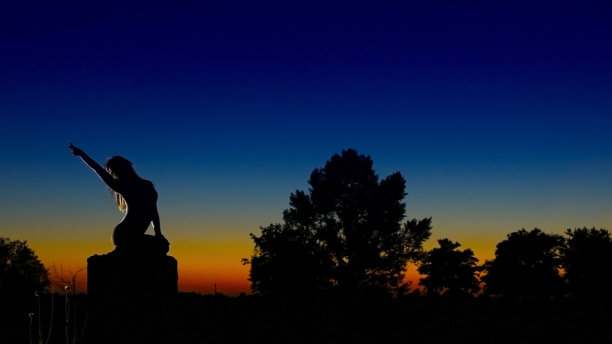 傍晚，优雅的女孩坐在柱子上为我们引路图片下载