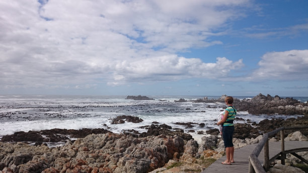 妈妈抱着她的孩子望着大海图片下载