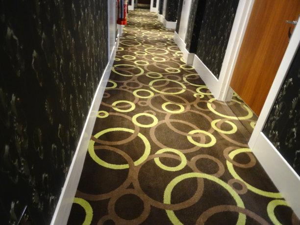 形象的酒店走廊，木质的卧室门，棕色的地毯圈图片下载