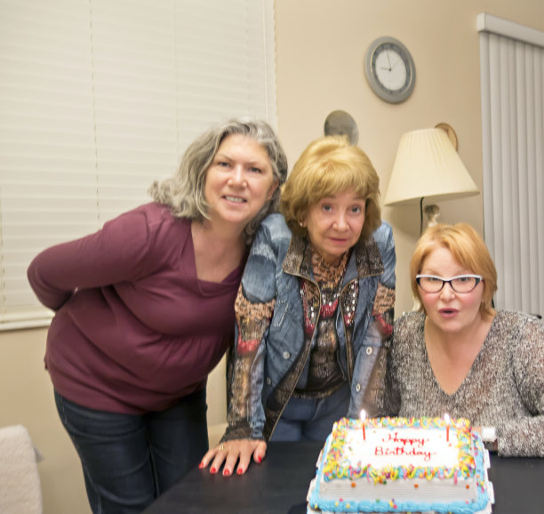 生日快乐。大四学生吹灭蛋糕上的蜡烛图片下载