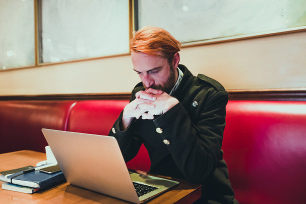 一个拿着笔记本电脑的男人在咖啡馆里图片下载