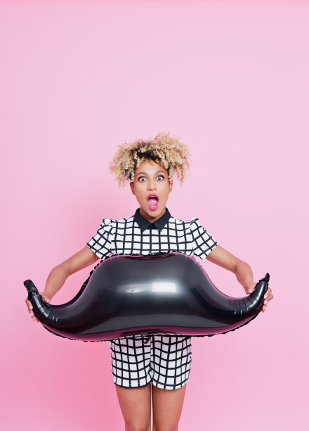 美国黑人年轻女子拿着胡子气球图片下载