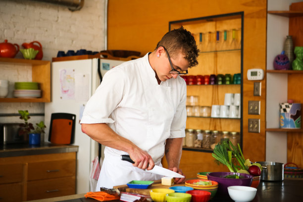 英俊的厨师在现代厨房烹饪图片下载