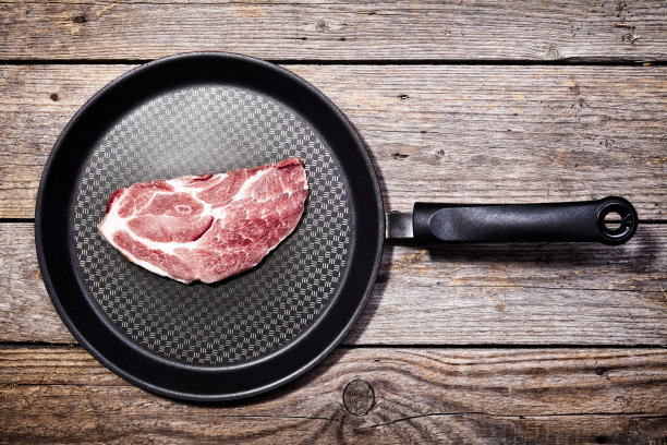 木头上的锅里的一片猪肉图片下载