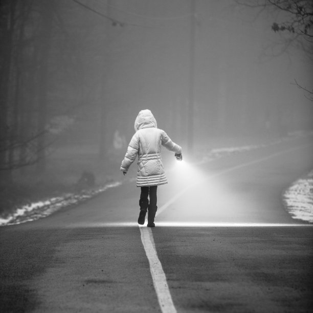 少女拿着手电筒在阴霾中行走图片下载