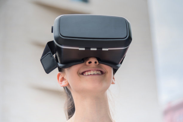 带着虚拟现实模拟器的微笑女孩图片下载