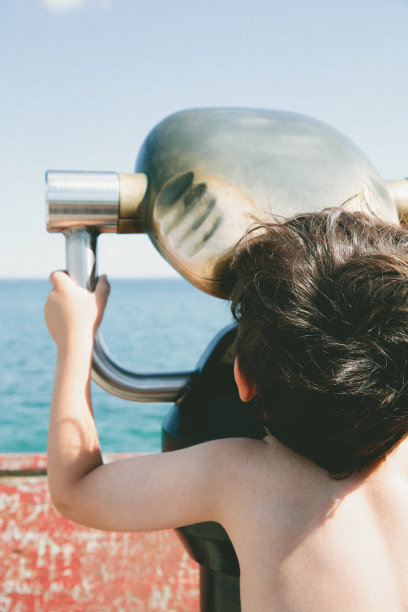 小男孩用双筒望远镜看图片下载