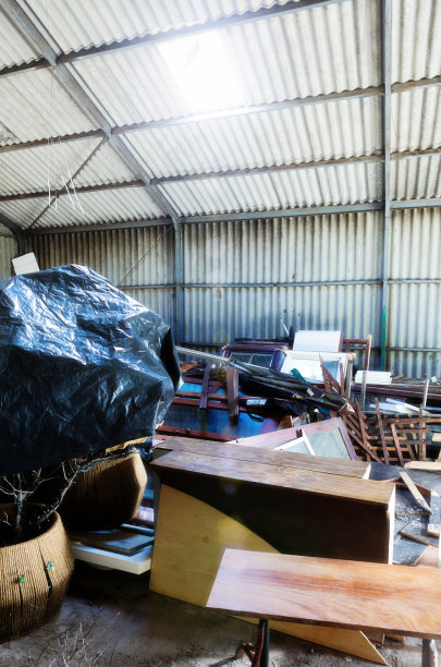 垃圾:谷仓里堆满了旧的、用过的建筑部件和家具图片下载