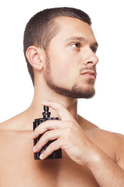 年轻英俊的男子正在擦香水图片下载