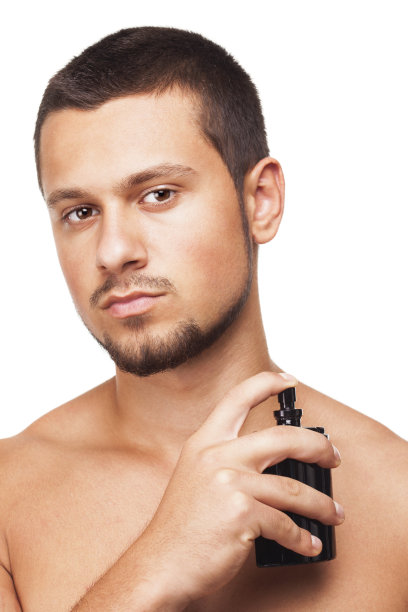 年轻英俊的男子正在擦香水图片下载