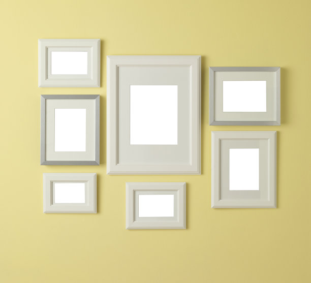 黄色的墙上挂着七个空白的相框图片下载