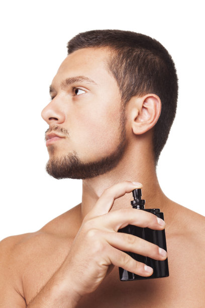 年轻英俊的男子正在擦香水图片下载