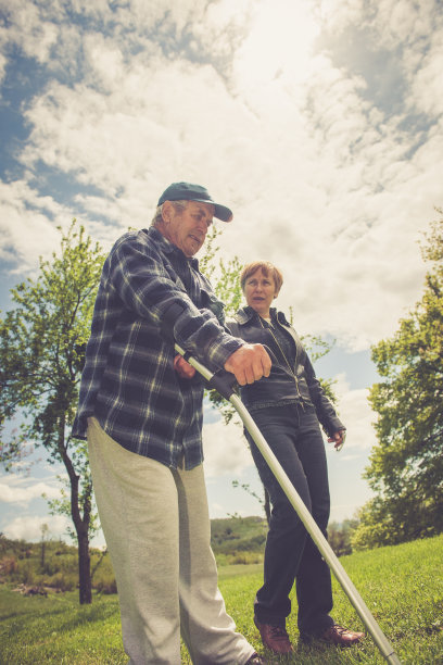 老人拄着拐杖在女儿的帮助下行走图片下载