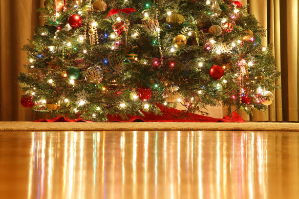 圣诞树上的灯光反射在木地板上图片下载