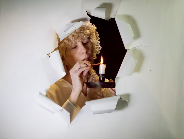 迷人的资深女性点燃一支蜡烛图片下载