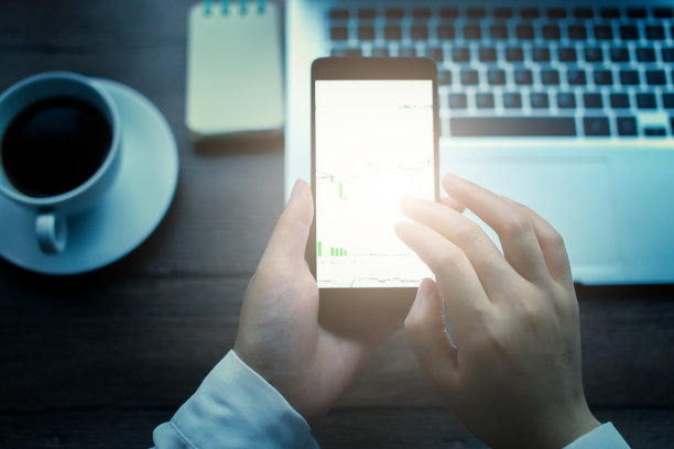 手持智能手机与股票图表图片下载