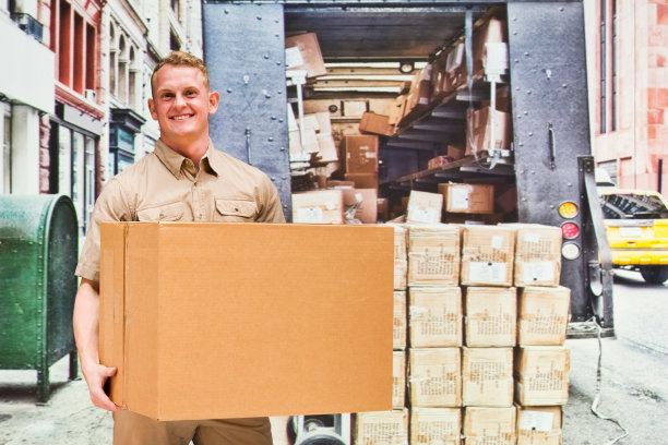 微笑的送货人在户外拿着盒子图片下载