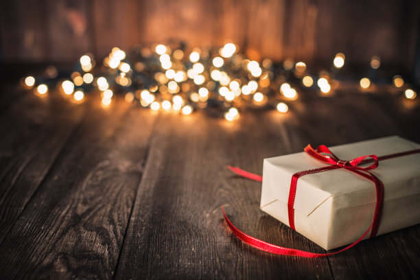 旧木板上的圣诞礼物和散焦灯素材图片