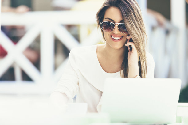 女商人在咖啡店里用智能手机聊天，面带微笑图片下载