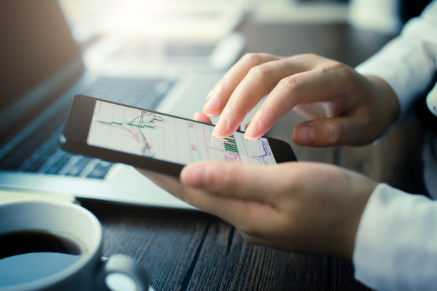 手持智能手机与股票图表图片下载