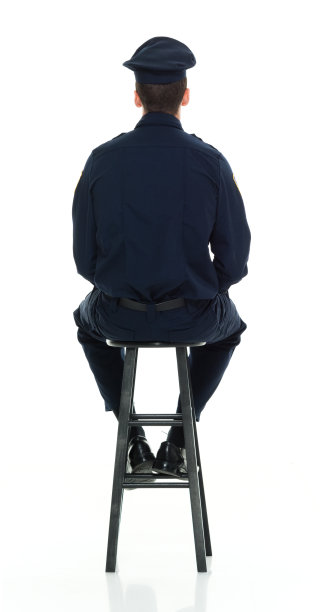 警察坐在凳子上的后视图图片下载