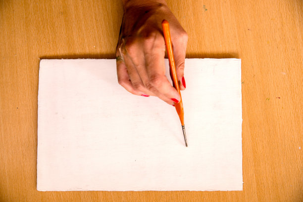 手和画笔在白纸上图片下载