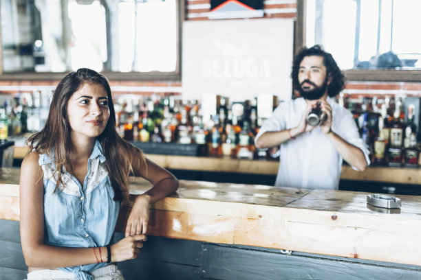 一个年轻女子坐在酒吧里图片下载