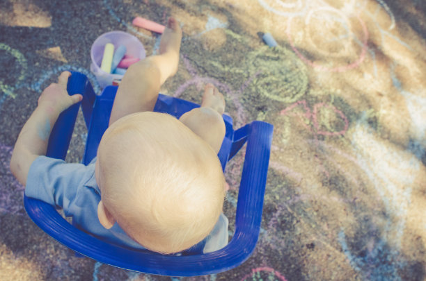 金发小孩在地板上玩彩色粉笔图片下载