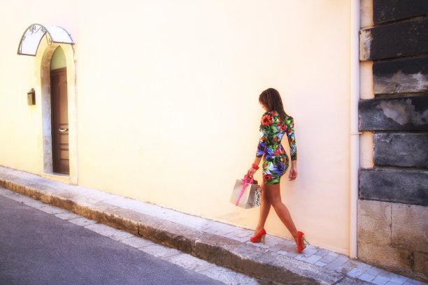 别致的年轻美女与购物袋对苍白的墙图片下载