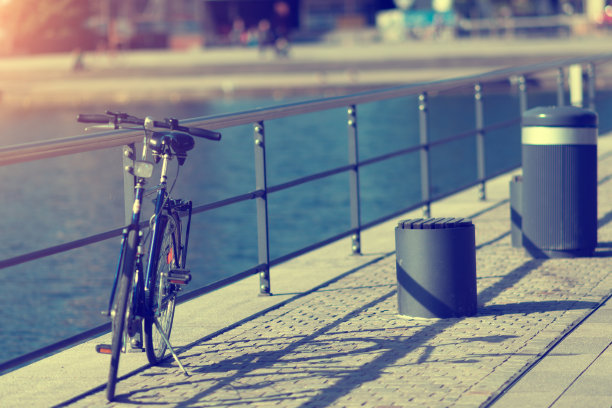 在城市水边的栏杆上骑自行车图片下载