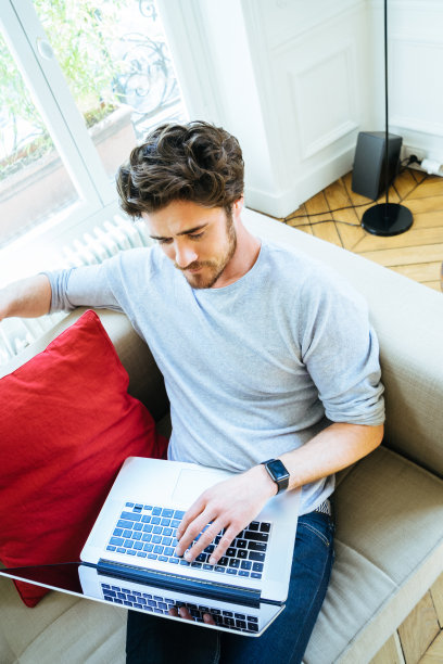 一个坐在沙发上用笔记本电脑的男人图片下载