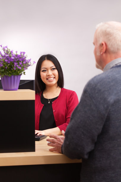 银行出纳员在零售银行服务柜台为客户服务图片下载