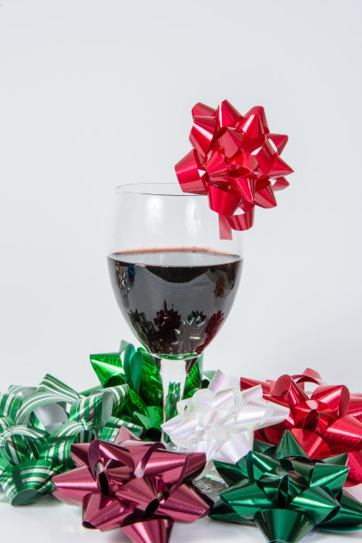 一杯带节日蝴蝶结的红酒图片下载