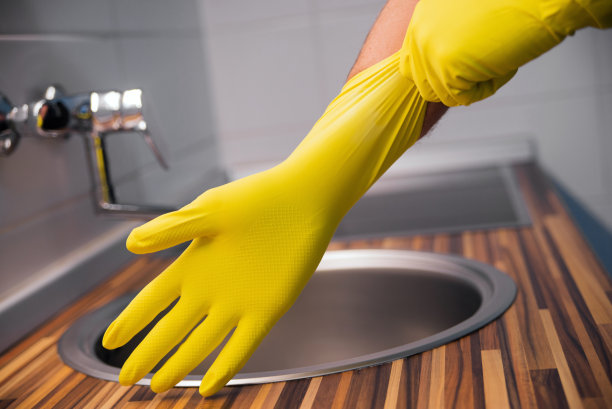 戴着黄色橡胶手套的年轻人。准备好清洁图片下载